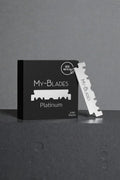 My-Blades Platinum 100 half blades in matte black packaging displayed on textured pedestal with single double-edge blade standing upright beside the box.