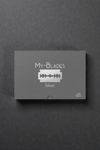 My-Blades Silver Professional 100 razor blades with box and single blade displayed upright on a reflective gray surface.