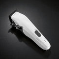 Angled studio image of the white Tensor1 clipper on a dark textured surface, showcasing its clean modern design, ergonomic controls, and precision blade head.